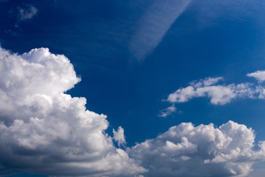 Regular spring clouds on blue sky at daylight in continental europe. Close shot wit telephoto lens and circular polarizing filter.