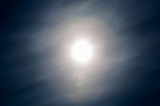 dust particles flying in the air on blue sky background with sun and feather cloud at spring day.
