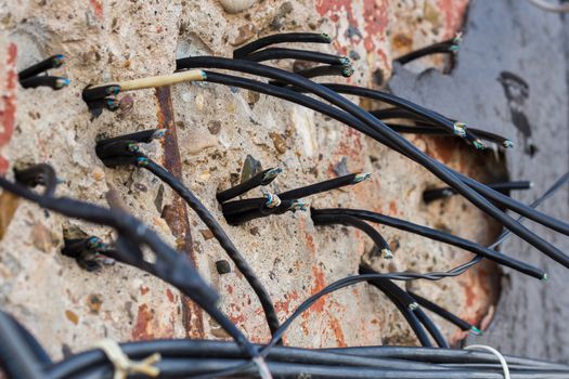 cutted wires on concrete wall closeup whit selective focus.