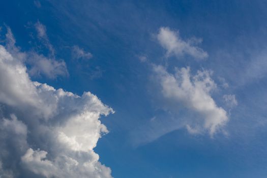 Regular spring clouds on blue sky at daylight in continental europe. Close shot wit telephoto lens and circular polarizing filter.