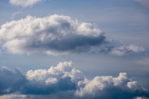 Regular spring clouds on blue sky at daylight in continental europe. Shot wit telephoto lens and circular polarizing filter.