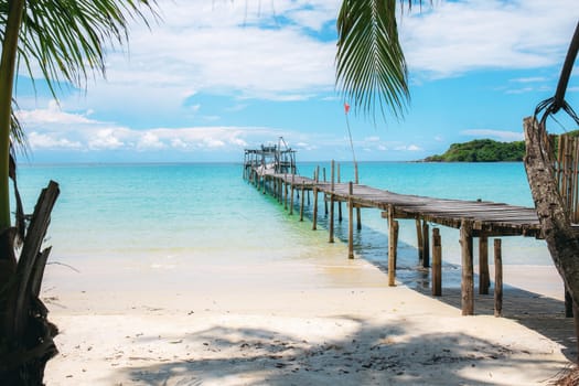 Wooden bridge on beach at the sea with blue sky.