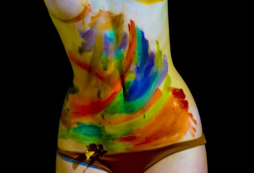 Body art. Drawing on the body. Beautiful girl with painted body watercolors. A white young girl painted the body with paint.