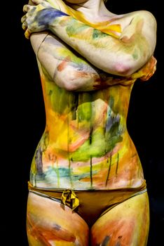 Body art. Drawing on the body. Beautiful girl with painted body watercolors. A white young girl painted the body with paint.