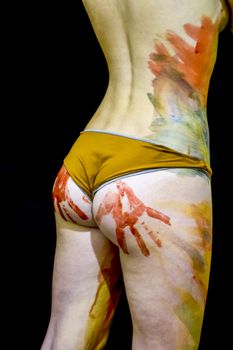 Girl with traces of the palms on the buttocks. Paint on the ass. Body art. Drawing on the body. Beautiful girl with painted body watercolors. A white young girl painted the body with paint.