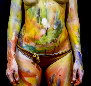 Body art. Drawing on the body. Beautiful girl with painted body watercolors. A white young girl painted the body with paint.