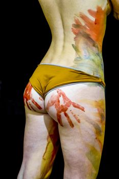 Girl with traces of the palms on the buttocks. Paint on the ass. Body art. Drawing on the body. Beautiful girl with painted body watercolors. A white young girl painted the body with paint.