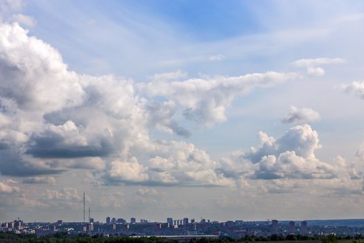 russian summer daylight cityscape with large cumulus clouds and tiny horizon line of the panel condominium houses.