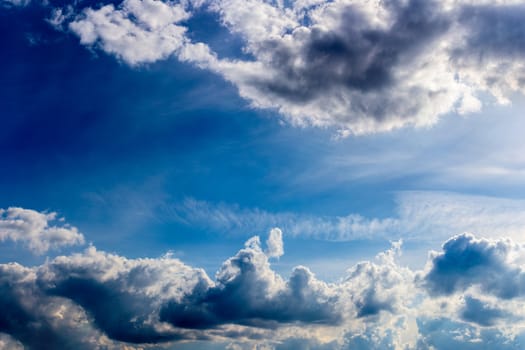distant misty backlit cumulus and feather clouds near horizon closeup telephoto shot with polarizing effect