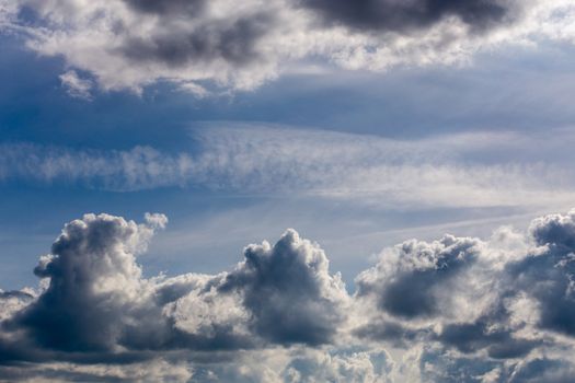 distant misty backlit cumulus and feather clouds near horizon closeup telephoto shot with polarizing effect