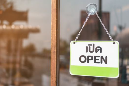 A business sign that says open on cafe or restaurant hang on door at entrance. Vintage color tone style.