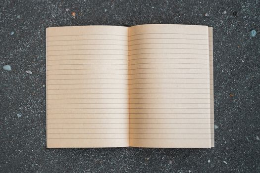 Small white notebook on sand at beautiful beach sea texture background.