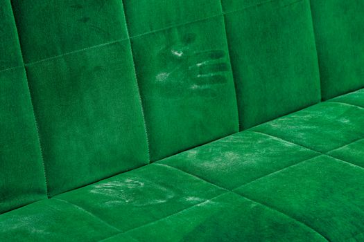 dusty green sofa surface with palm prints closeup with selective focus.