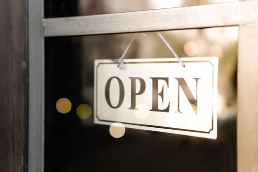 A business sign that says open on cafe or restaurant hang on door at entrance. Vintage color tone style.