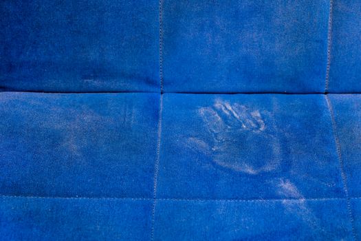 dusty blue sofa surface with palm prints closeup with selective focus.