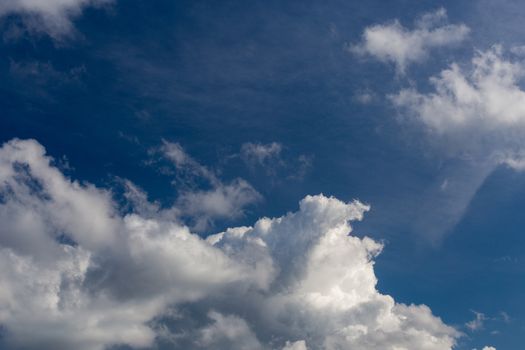 Regular spring clouds on blue sky at daylight in continental europe. Close shot wit telephoto lens and circular polarizing filter.
