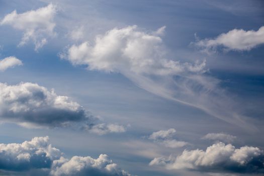 Regular spring clouds on blue sky at daylight in continental europe. Shot wit telephoto lens and circular polarizing filter.