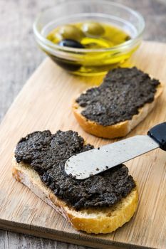 Black olive tapenade with anchovies, garlic and olive oil on wooden table