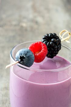 Healthy berry smoothie in glass on wooden table