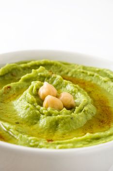 Avocado hummus in bowl isolated on white background