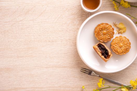 Mid-Autumn Festival holiday concept design of moon cake, mooncakes, tea set on bright wooden table with copy space, top view, flat lay, overhead shot