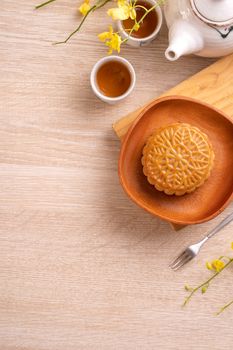 Mid-Autumn Festival holiday concept design of moon cake, mooncakes, tea set on bright wooden table with copy space, top view, flat lay, overhead shot