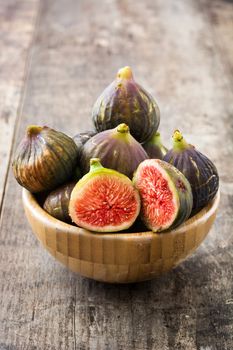 Fresh figs on wooden bowl and wooden background