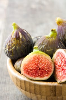 Fresh figs on wooden bowl and wooden background