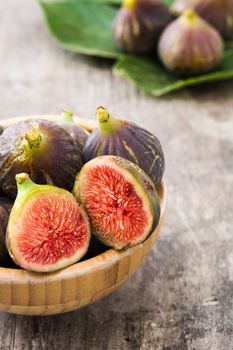 Fresh figs on wooden bowl and wooden background