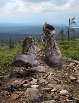 Hiking boots walking onstony wilderness path background, outdoor trekking activity concept