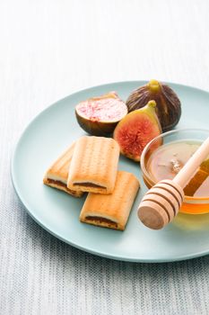 Fig cookies with honey on blue background