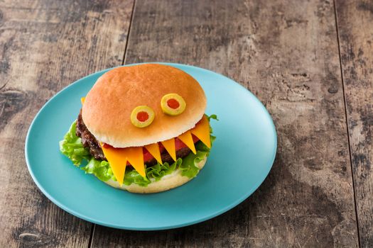 Halloween burger monsters on wooden table
