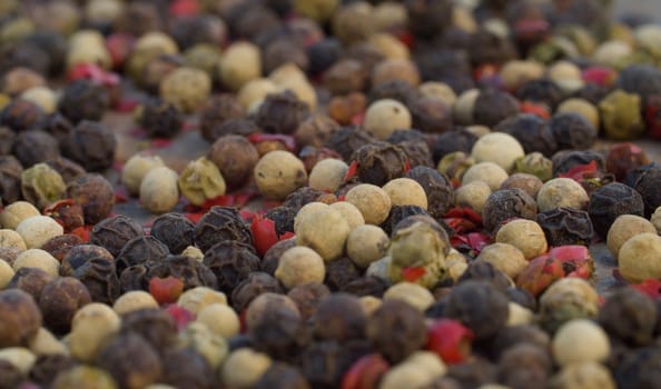 Macro shot of black, white and red peppercorns mix - aromatic spice. Extreme close up