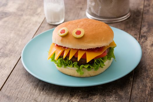 Halloween burger monsters on wooden table