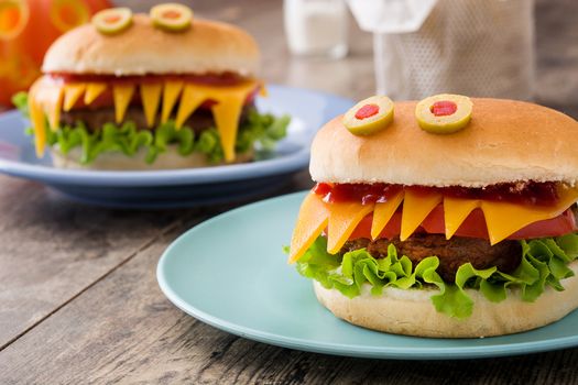 Halloween burger monsters on wooden table