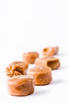 Toffee caramel candies isolated on white background. Copyspace.