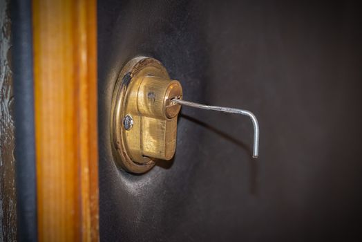 Lock picking, a tension wrench is inserted in the lock of a security door