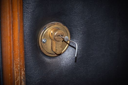 Lock picking, a tension wrench is inserted in the lock of a security door
