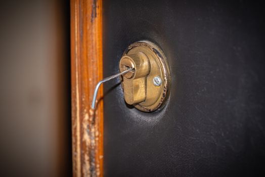 Lock picking, a tension wrench is inserted in the lock of a security door