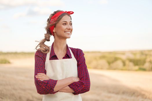 Woman farmer apron standing farmland smiling Female agronomist specialist farming agribusiness Happy positive caucasian worker agricultural field Pretty girl arms crossed dressed red checkered shirt