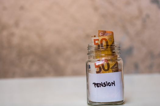 Composition with saving money banknotes in a glass jar. Concept of investing and keeping money, close up isolated.