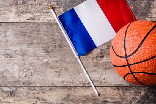 Basketball and French flag on wooden table. Top view.