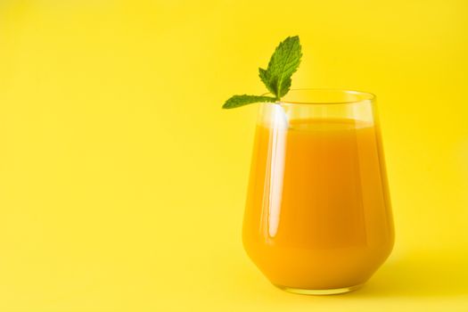 Mango Lassi dessert. Traditional Indian drink on yellow background.
