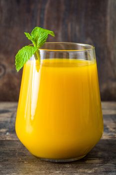 Mango Lassi dessert. Traditional Indian drink on wooden table. Copyspace