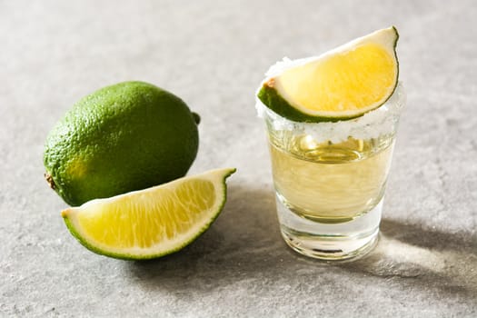 Mexican Gold tequila with lime and salt on gray background