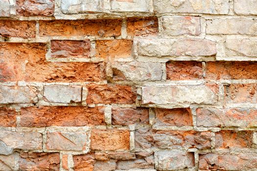 Background texture and piece of brickwork. Old ruined red brick wall with cracked and broken bricks, image with copy space.
