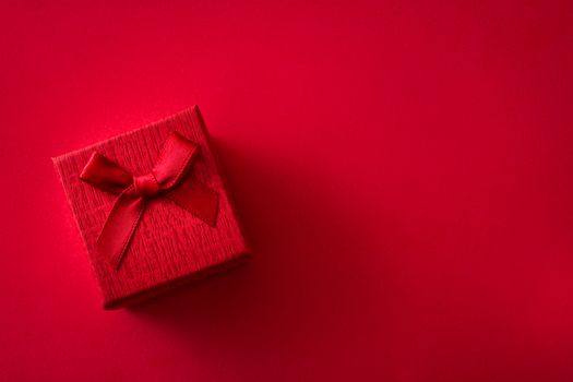 Red gift box on red background. Top view