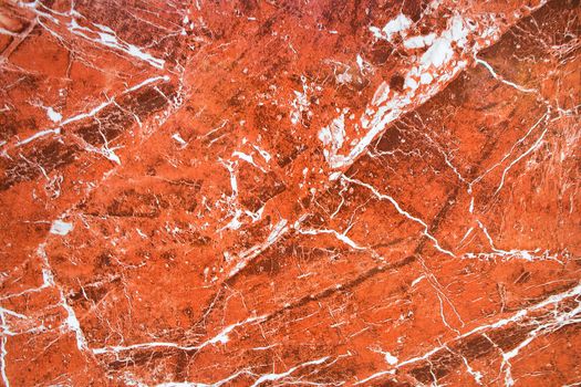 Amazing fiery view on a background of red granite stone with white veins. The surface of natural red granite, polished crystalline and texture, mineral stone closeup, macro.