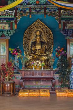 meditating golden buddha statue closeup photo in the shrine