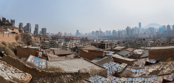 Poor part of chinese city with developed buildings in the background